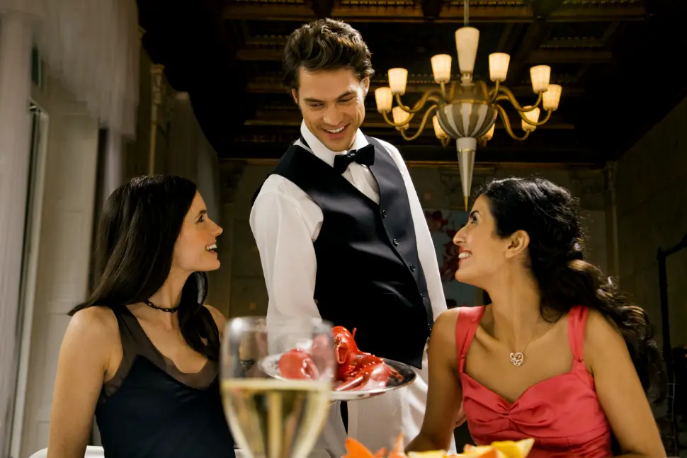 Waiter serving meals at a table in a restaurant using Xootle